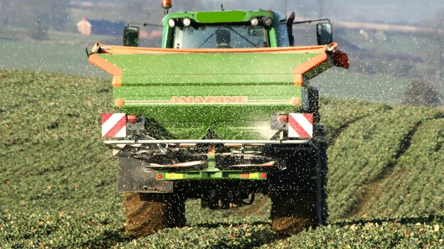 Granular fertiliser being spread by a tractor